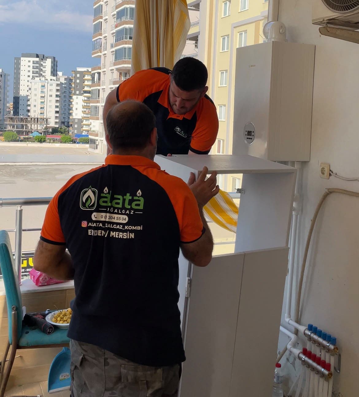 Alata Doğalgaz ekibi bir balkonda kombi montajı yaparken