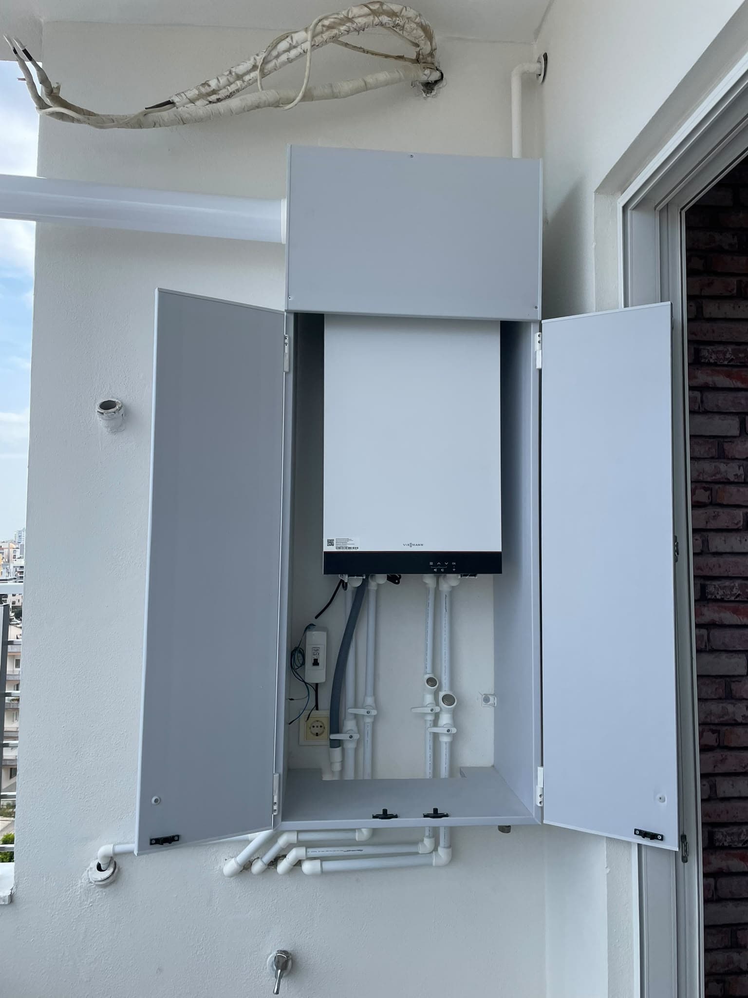 Balkonda monte edilmiş Viessmann kombi ve tesisat bağlantıları